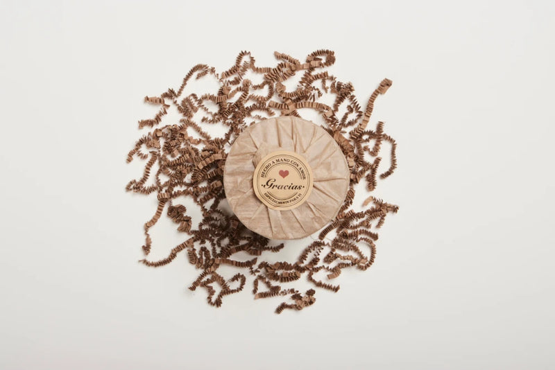 Bar of soap with a decorative brown ribbon on a white background